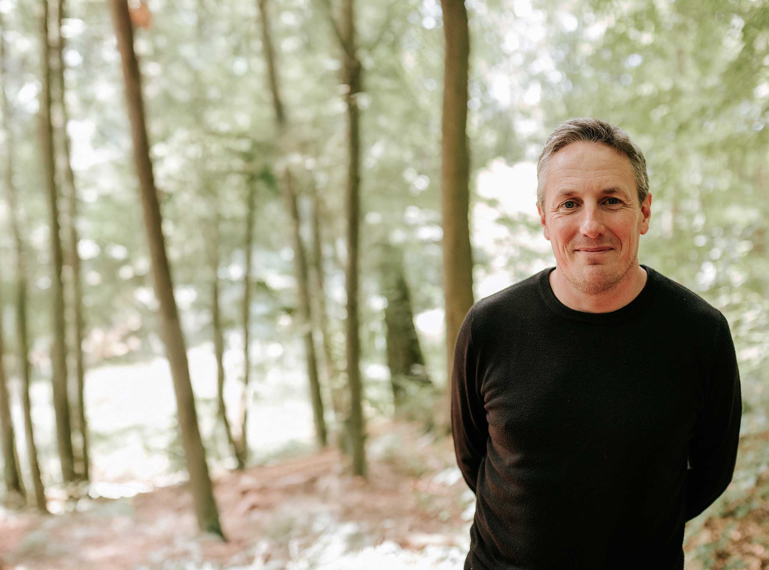 man in woods smiling at camera